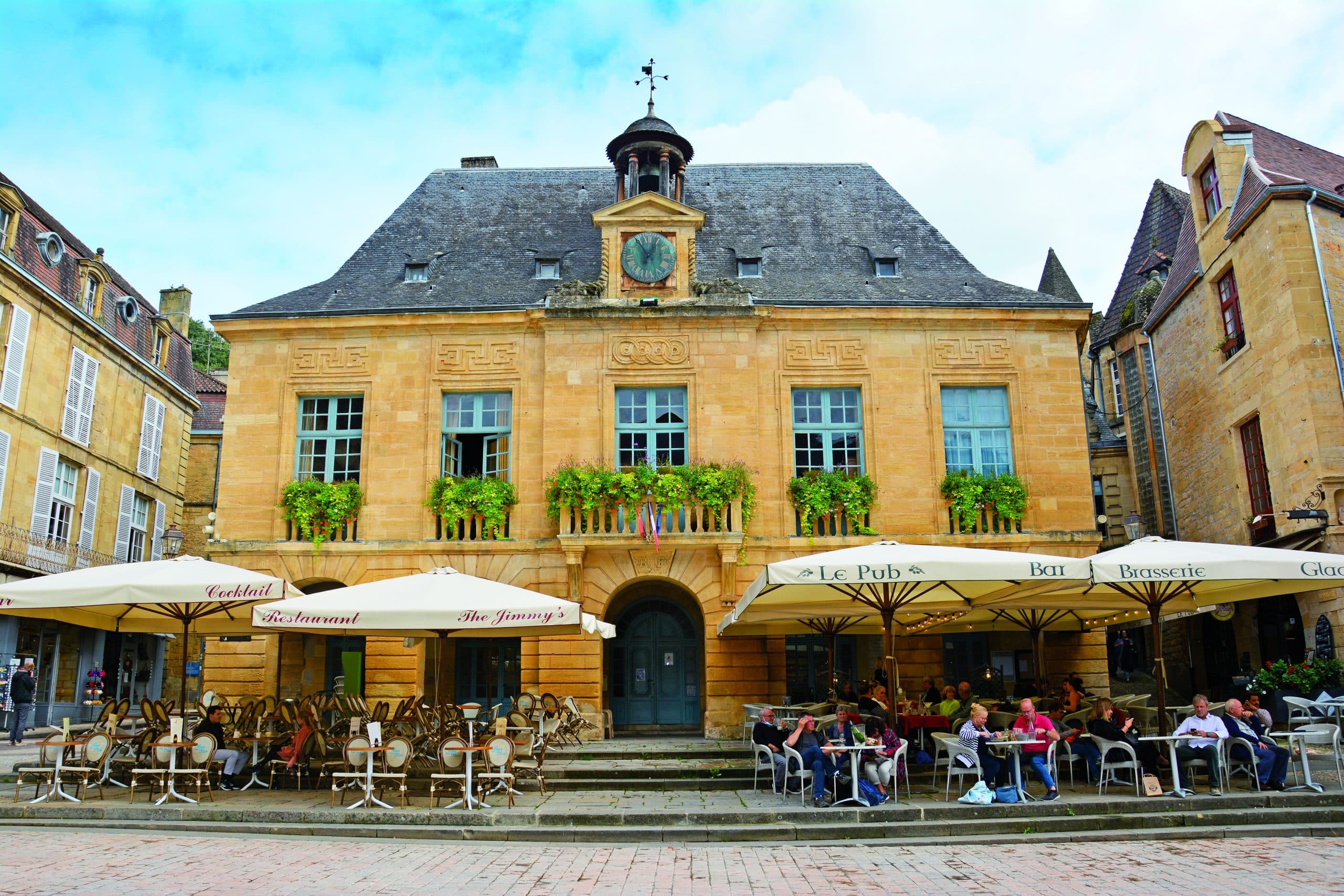 Altes Gebäude mit gelbem Mauerwerk und kleinem Glockenturm in Sarlat La Canéda