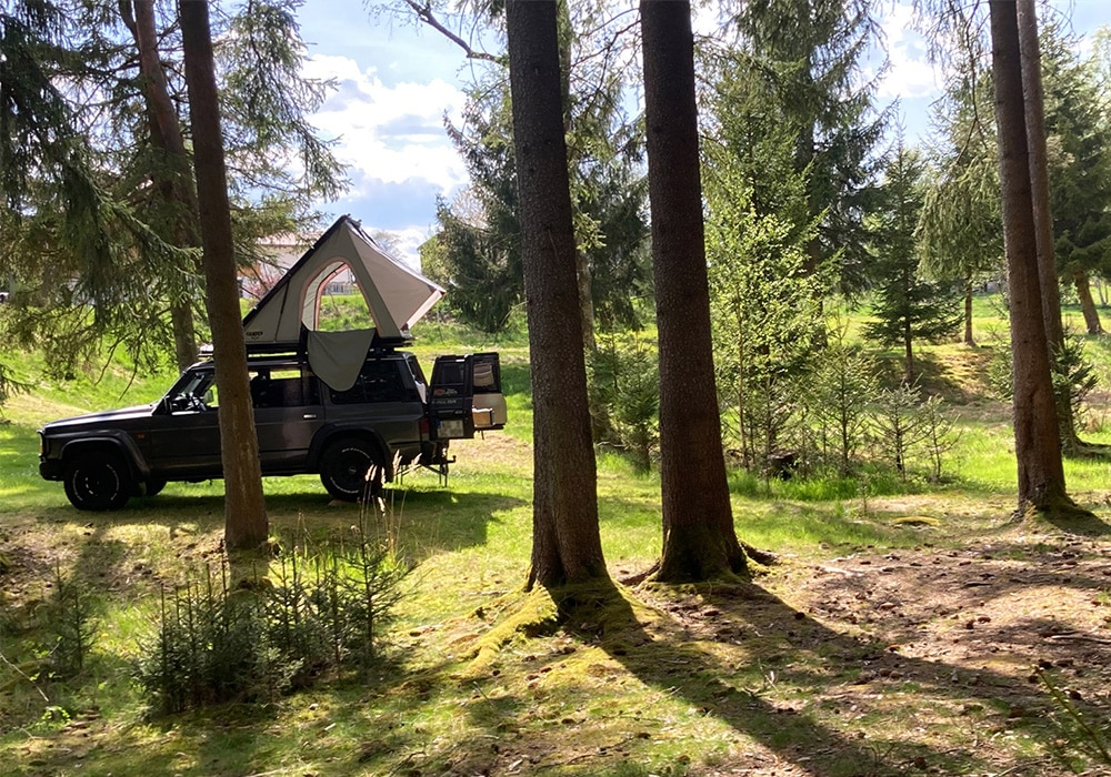 Auto mit Dachzelt im Wald.