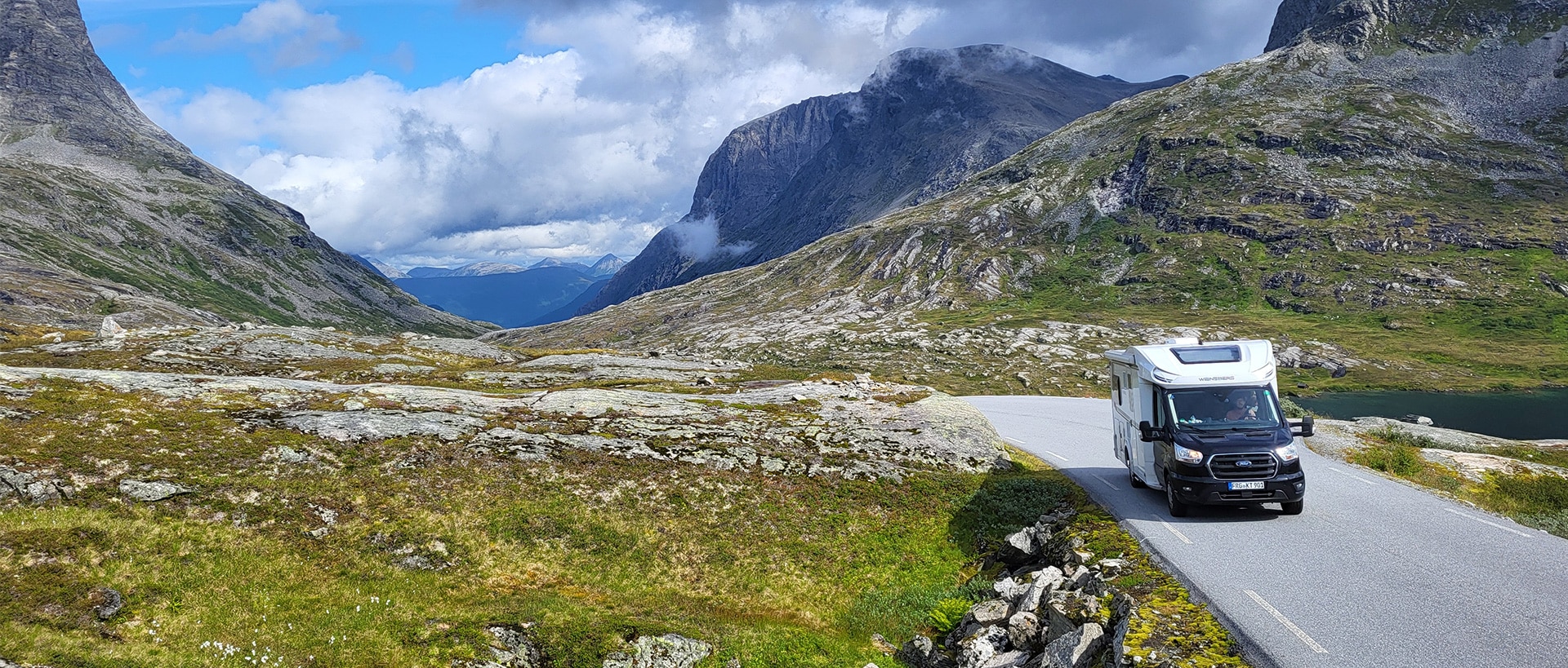 Wohnmobil fährt auf einer Straße, umgeben von norwegischer Landschaft
